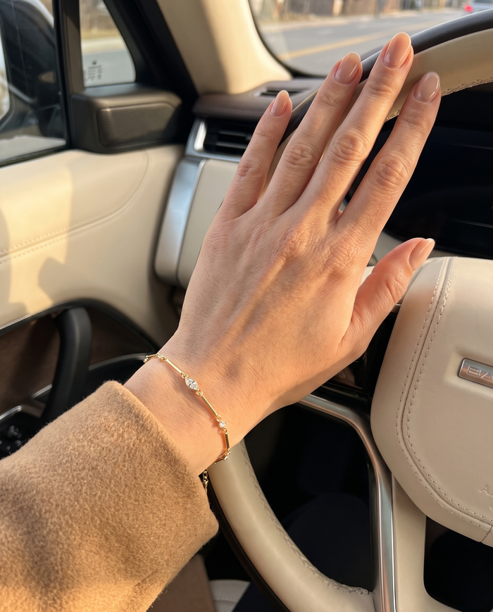 Pulsera Dalia dorada en la mano al volante